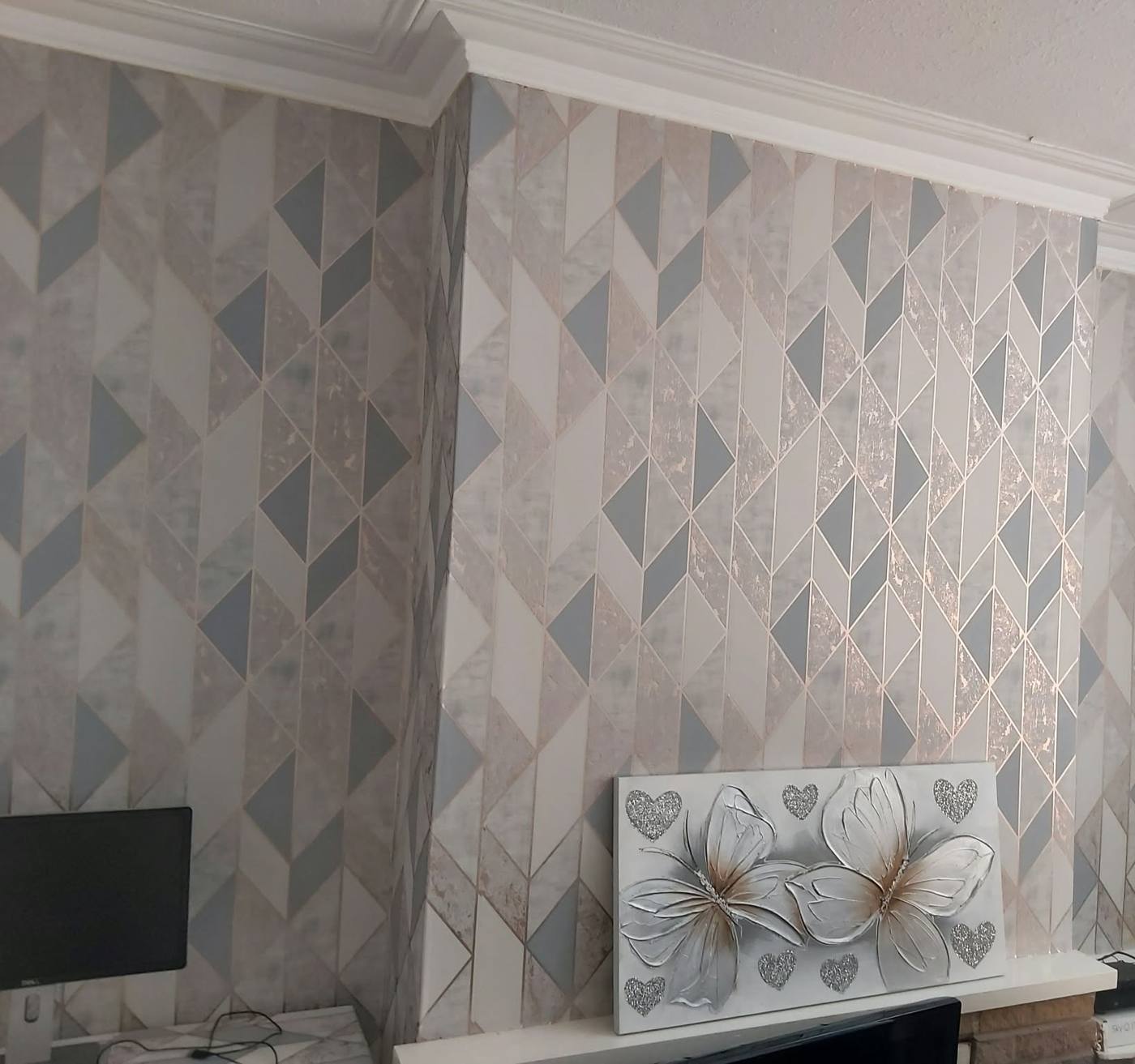 Living room with grey and rose-gold geometric wallpaper